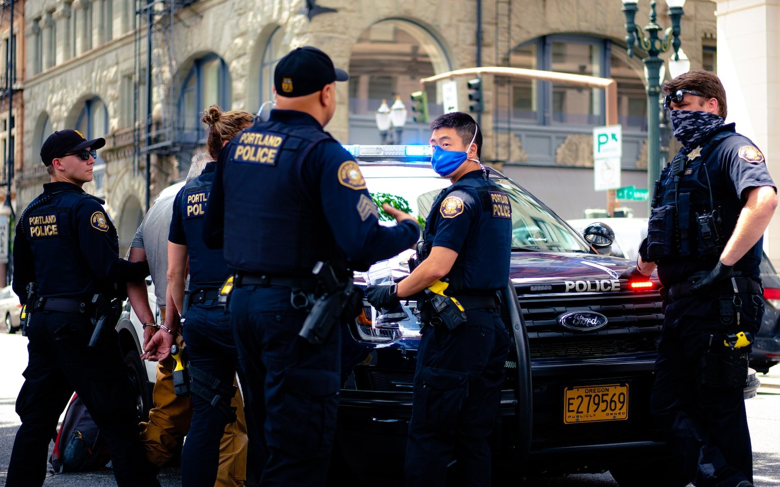 man in police uniform standing beside black car during daytime